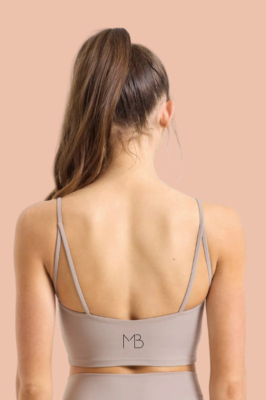 Woman wearing GAIA Recycled Luxe Gym Bra Top in Sandstone by Meraki Beach – sustainable activewear made from recycled nylon