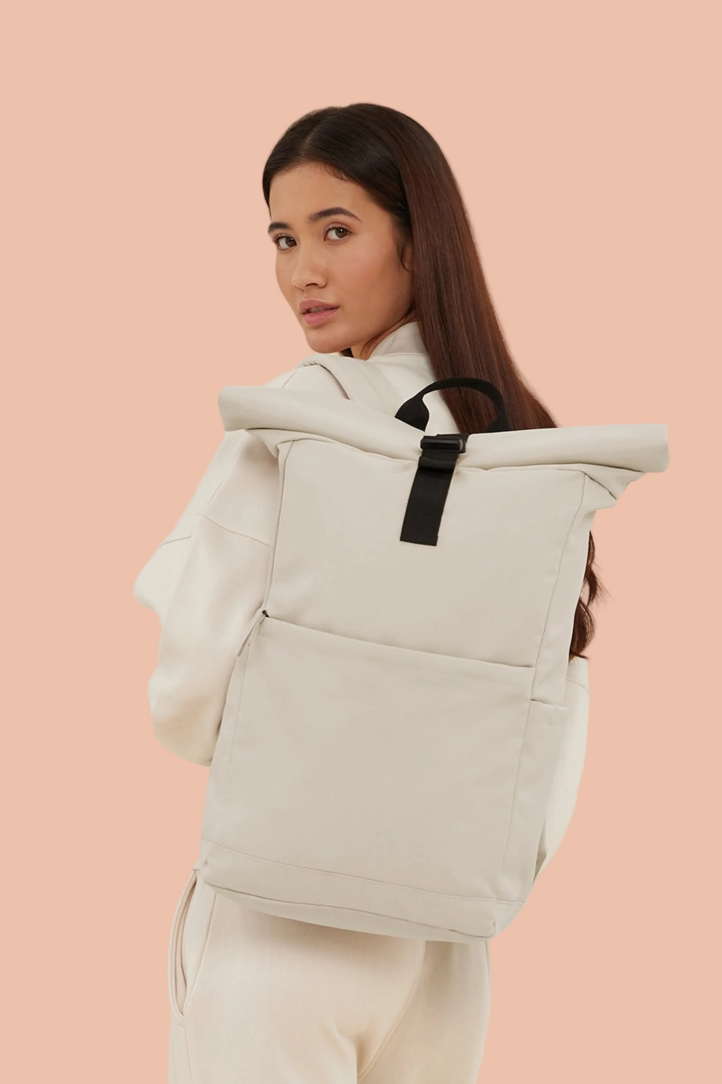 Woman with the Meraki Beach AVENTURA unisex roll-top backpack in Sandstone, minimalist sustainable bag designed for everyday adventure.
