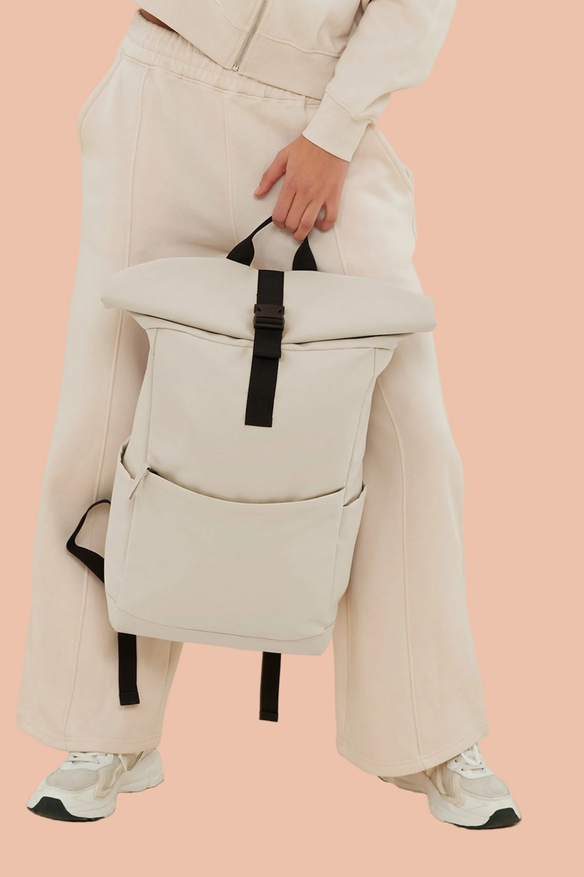 Woman with the Meraki Beach AVENTURA unisex roll-top backpack in Sandstone, minimalist sustainable bag designed for everyday adventure.