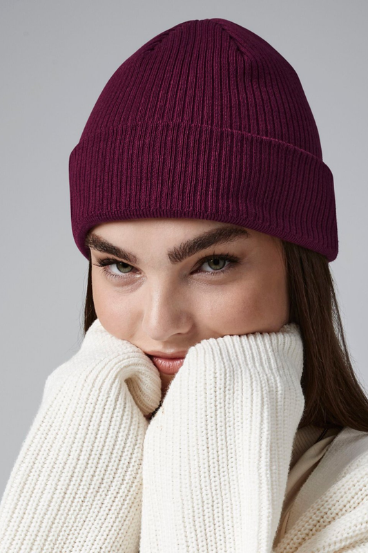 Model wearing The Cove Beanie in Berry by Meraki Beach – organic cotton rib knit hat in berry, sustainable unisex style