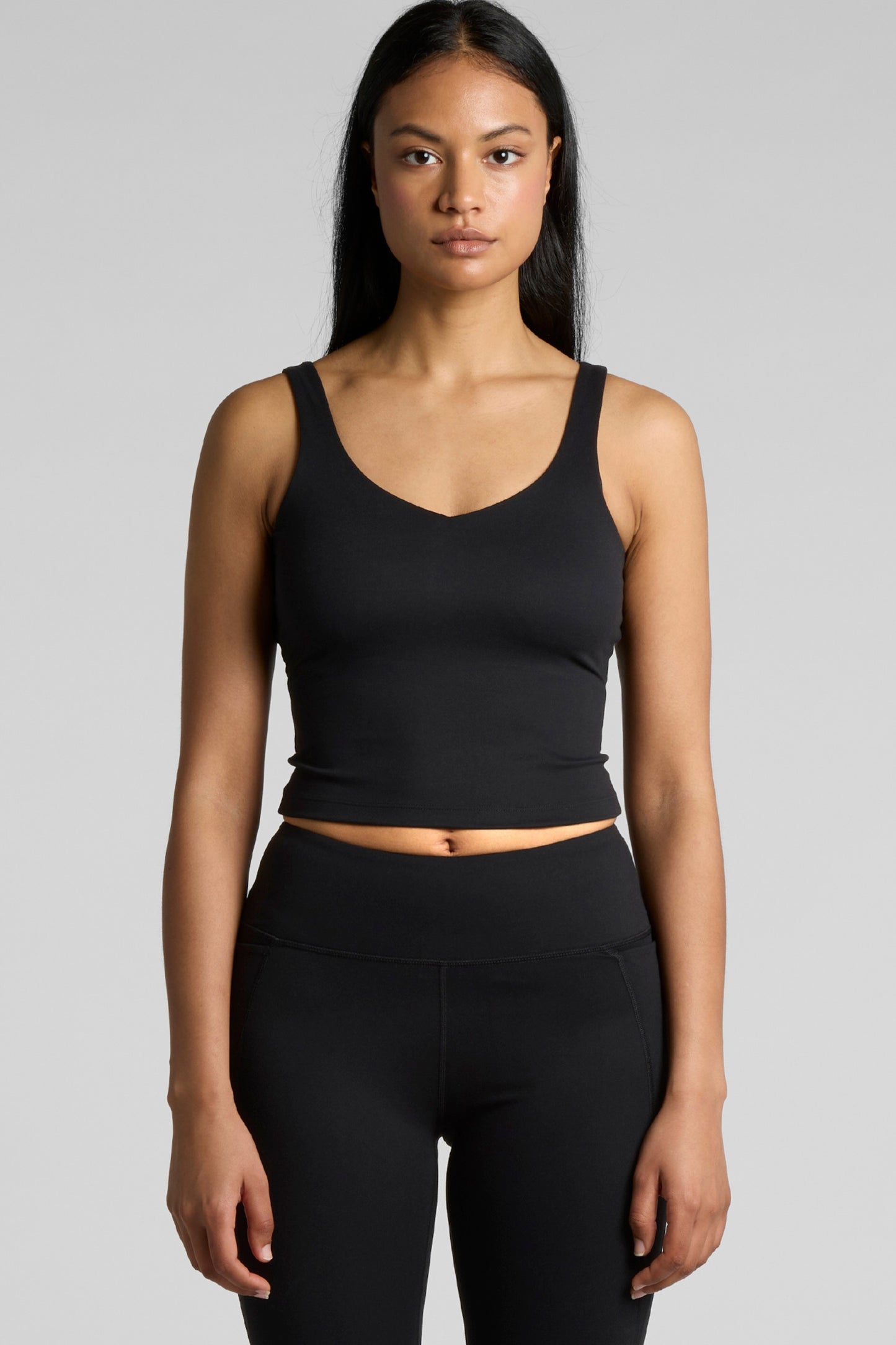 Woman wearing Meraki Beach MAREA Active Bra Tank Top in black, PFAS-free sustainable activewear made from recycled nylon for yoga, Pilates and everyday wear