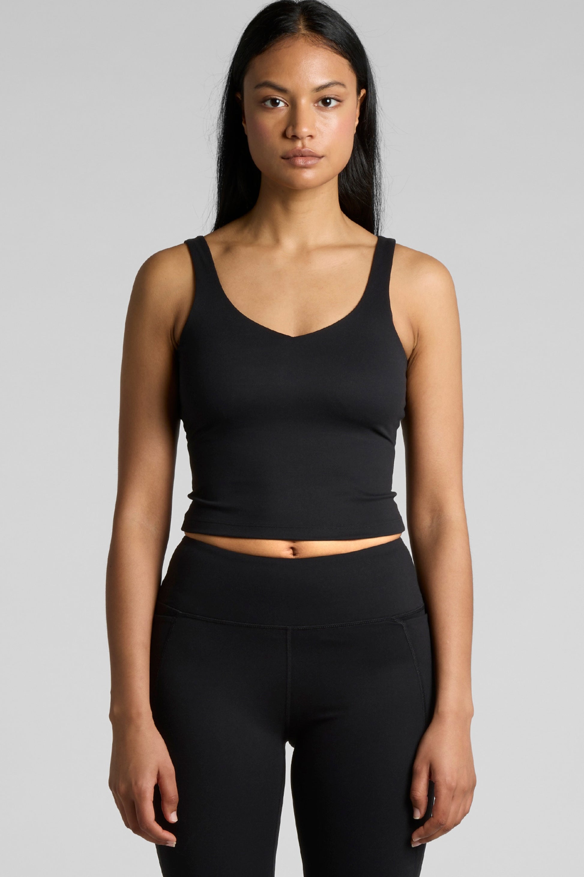 Woman wearing Meraki Beach MAREA Active Bra Tank Top in black, PFAS-free sustainable activewear made from recycled nylon for yoga, Pilates and everyday wear