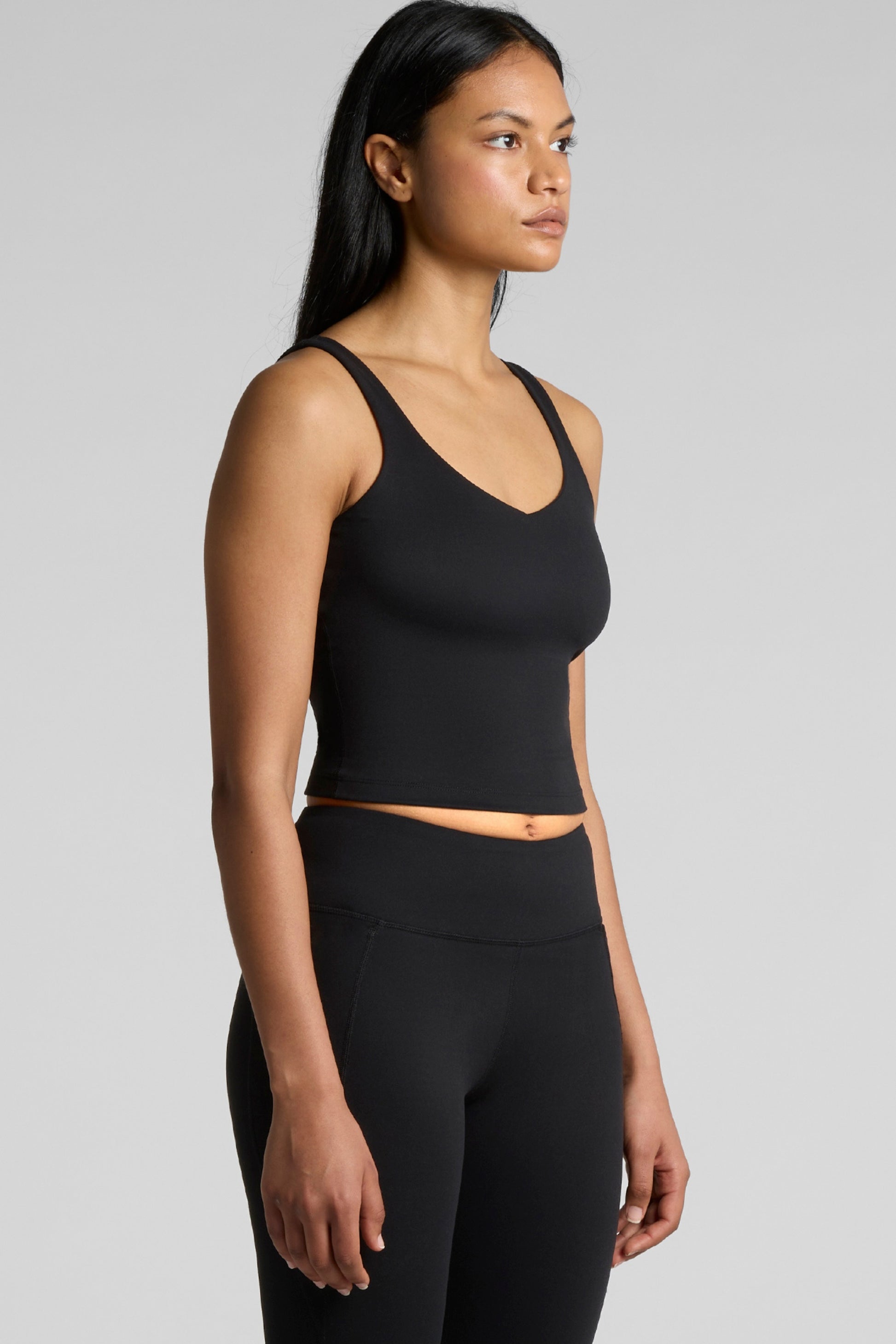 Woman wearing Meraki Beach MAREA Active Bra Tank Top in black, PFAS-free sustainable activewear made from recycled nylon for yoga, Pilates and everyday wear