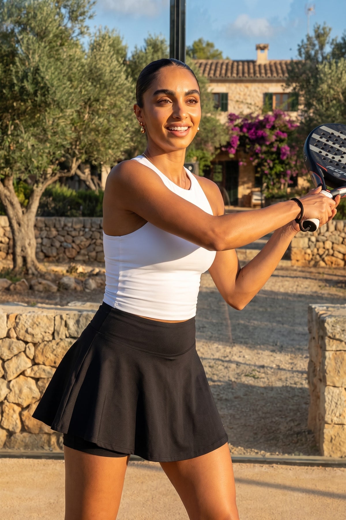 Woman playing padel and wearing PALMA sustainable fitness skort in Black by Meraki Beach – recycled activewear for padel, tennis and gym