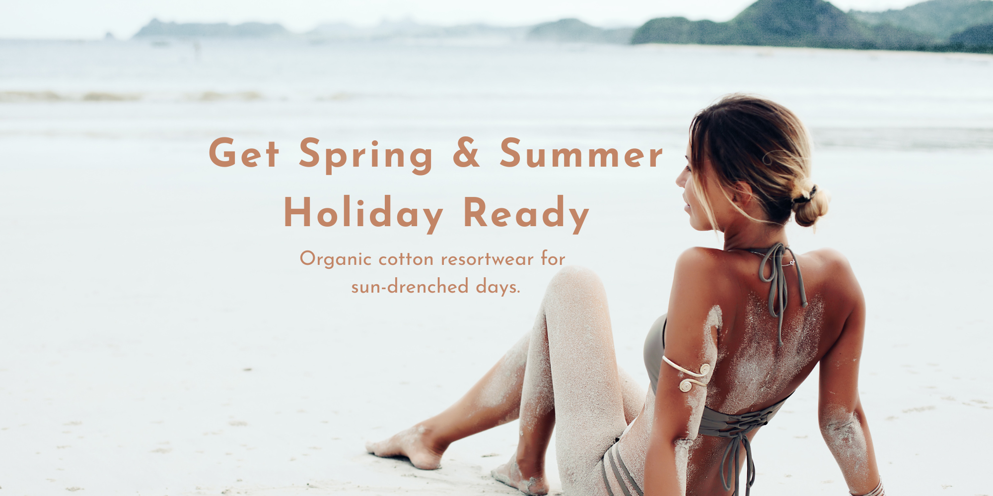 Woman relaxing on a beach wearing sustainable resortwear, promoting organic cotton holiday clothing for spring and summer by Meraki Beach.